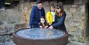 family underground in the Museum of Gloucester's Eastgate viewing chamber