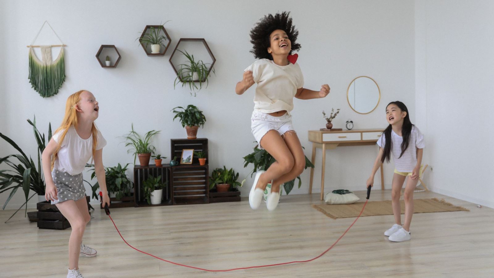 three girls skipping indoors