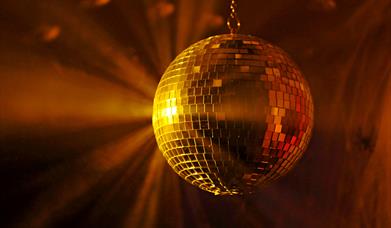 A mirror ball reflecting light in a smoky room