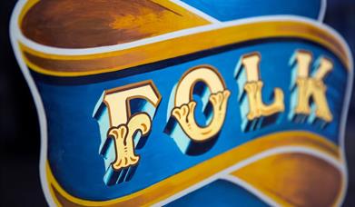 Folk art style bright painted text saying the word folk.