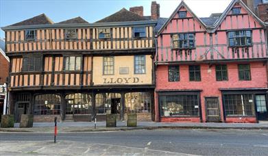 A photograph of a majestic half timbered Tudor building with mullioned windows