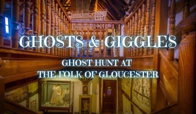 A photograph of the interior of The Folk of Gloucester's Tudor building with a sweeping wooden staircase, a timber framed ceiling and original 16th ce