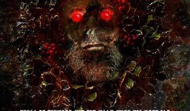 A Christmas ghost with red eyes peers towards the viewer from behind a distorted Christmas wreath.