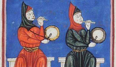 Two medieval musicians sitting down playing a pipe with one hand and a drum with the other.