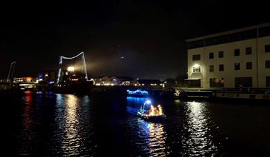Sleigh passing by an illuminated Sula Lightship