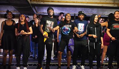 Young performers on stage in a car park