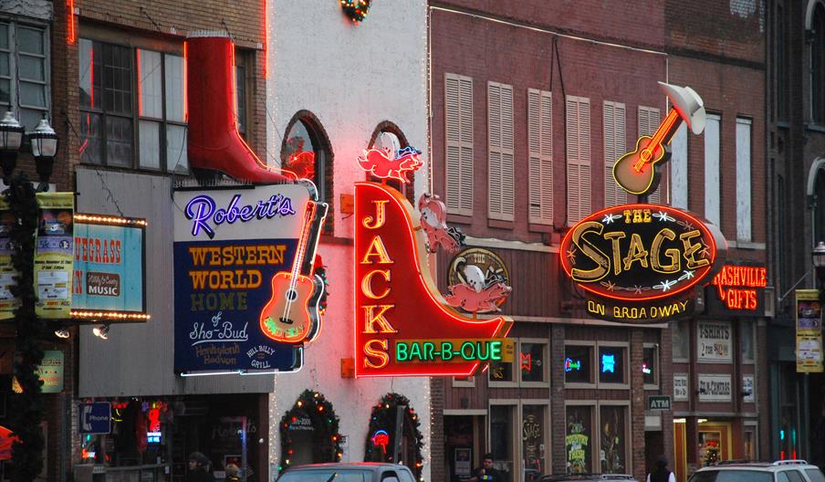 A street in Nashville, Tennessee with lots of neon signs for country music bars.