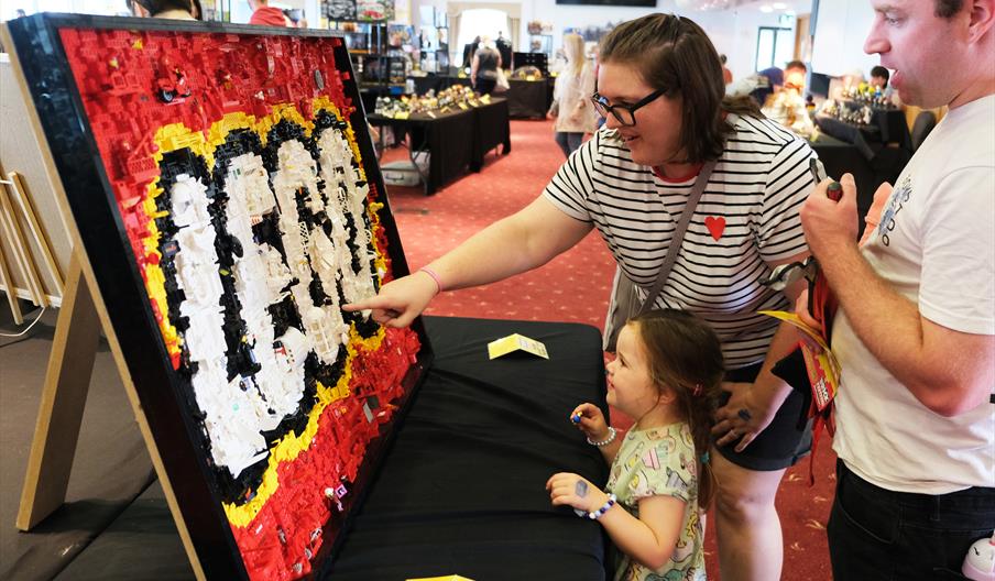A Family looking at a display of LEGO