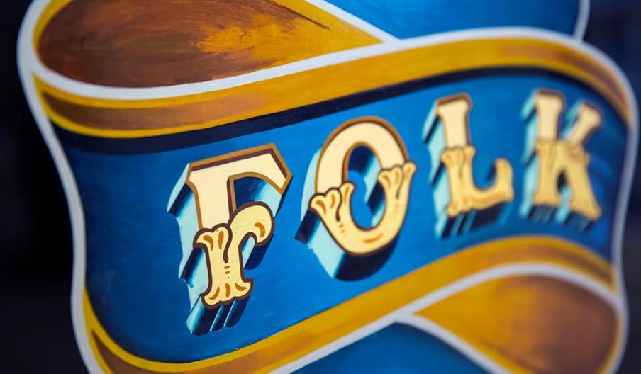 Folk art style bright painted text saying the word folk.