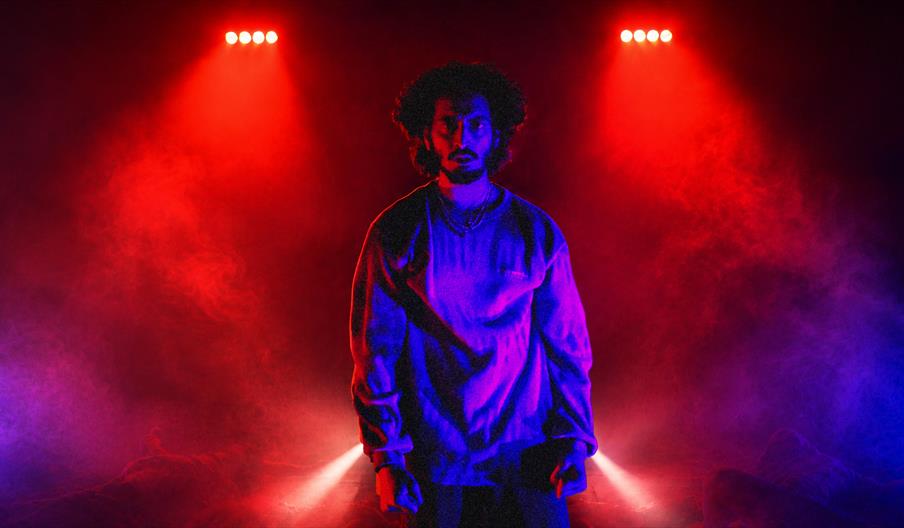 A performer on stage with bright red lighting
