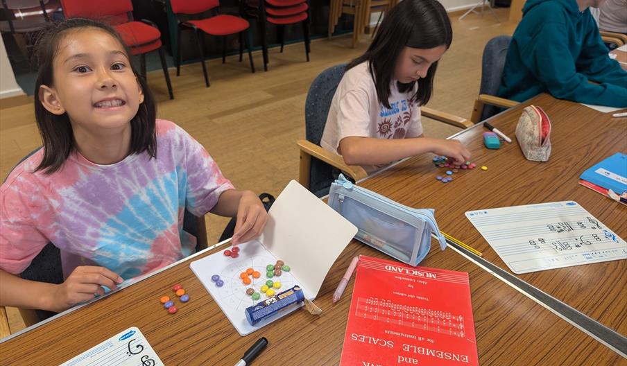 Student smiling with written task on the table