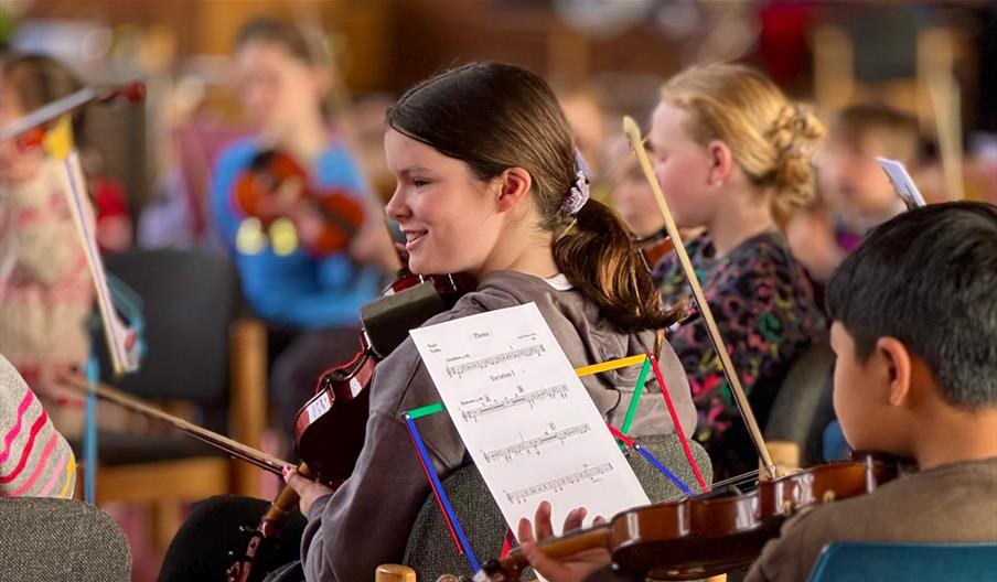 Child smiling holding violin