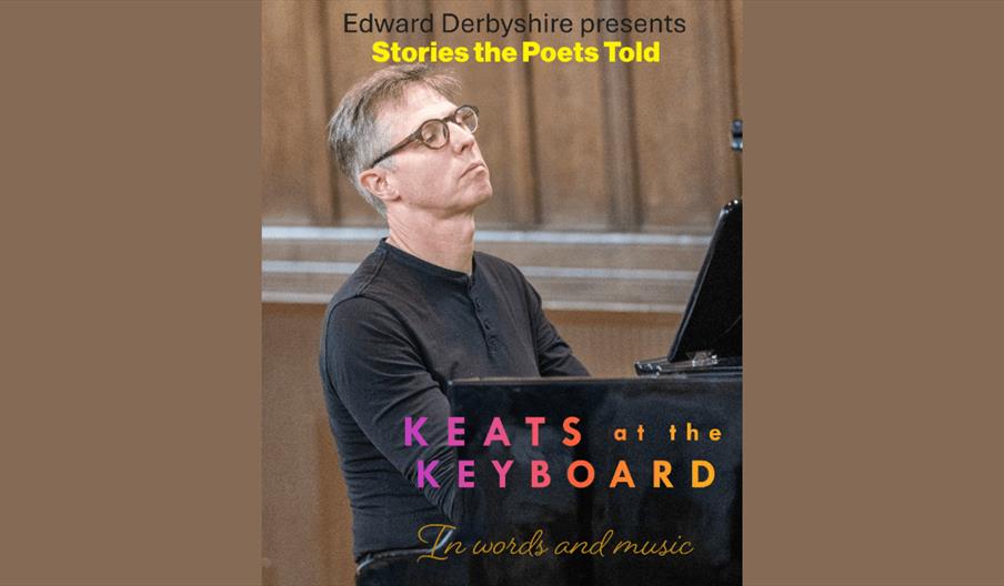 A man with short greyish brown hair and glasses sitting playing a piano