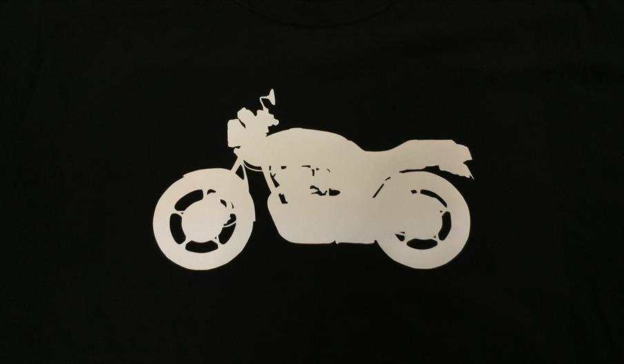 A black t shirt with a white motorcycle silhouette printed on it