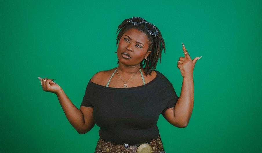 Muna Mone stood infront of green back drop