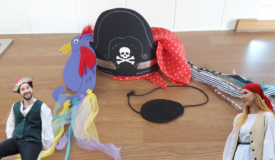 A hand made pirate hat, bandana, eye patch and parrot made from cardboard, fabric and paint