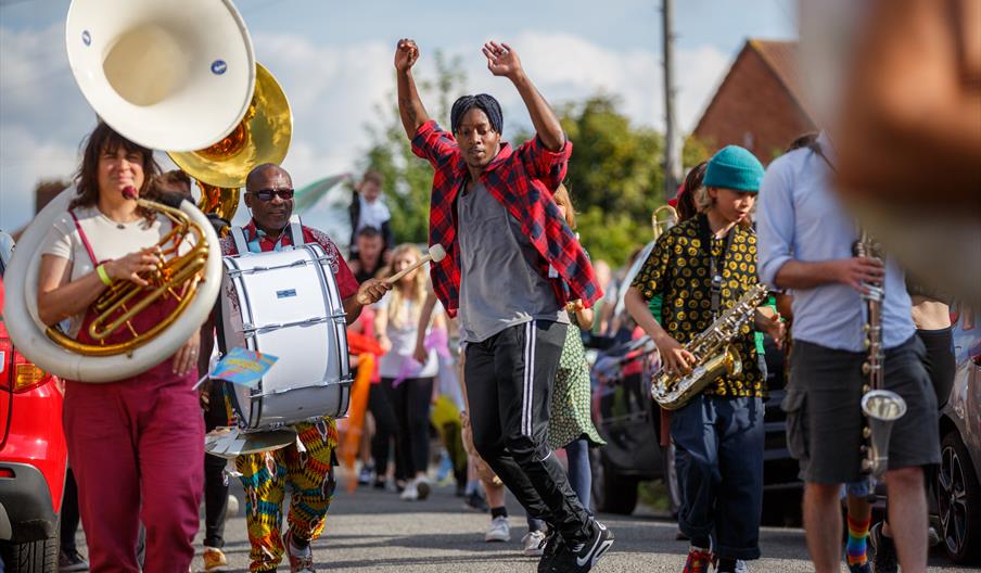A dancer in the street parade surrounded by musicians
