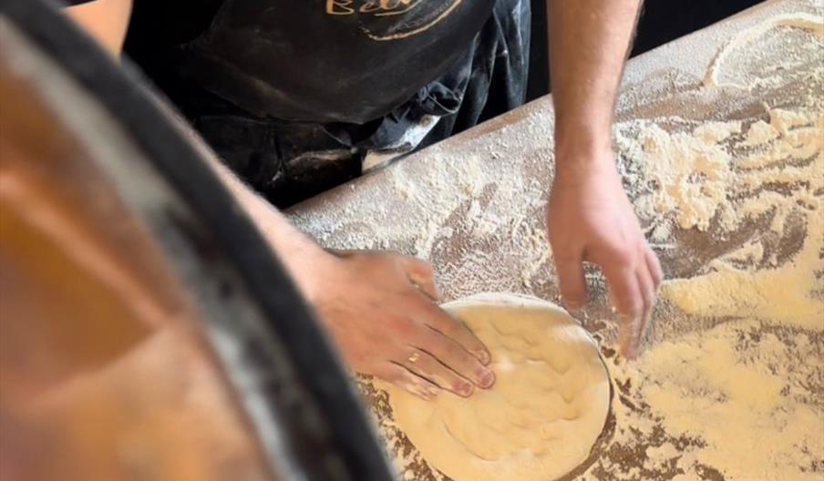 Pizza dough on a wooden table.