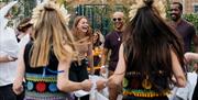 People laughing and joining in with morris dancing.