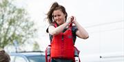 Women putting on life jacket for paddleboarding