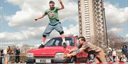A performer stood on top of a red spinning car.