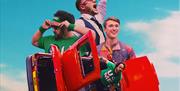 A poster image of three men and a red spinning car.