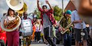 A dancer in the street parade surrounded by musicians