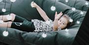 Girl sitting on beanbag within the Submergence lights