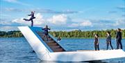 Dancers on a white staircase floating on water.