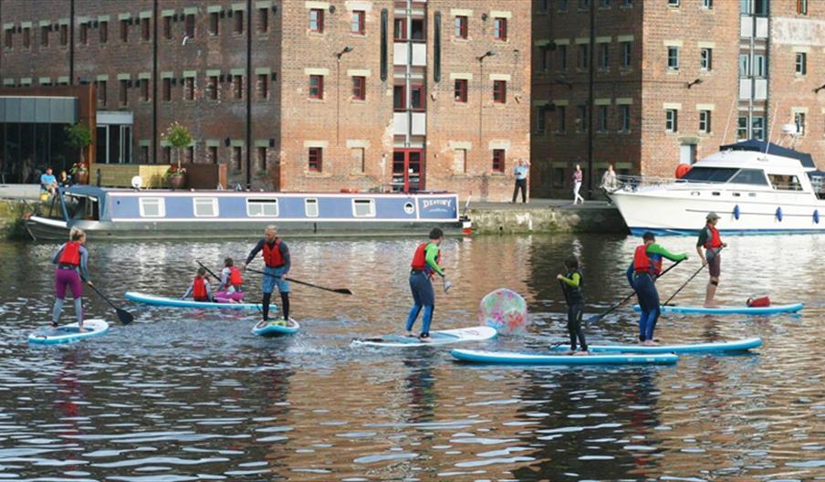 Photo of people paddleboarding in Gloucester Docks
