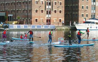Photo of people paddleboarding in Gloucester Docks